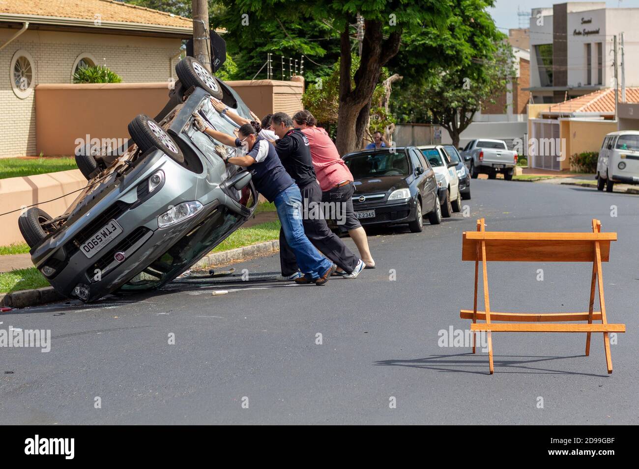 Ribeirao Preto, Brazil - January 21 2015: People help pull out an overturned car after a collision Stock Photo