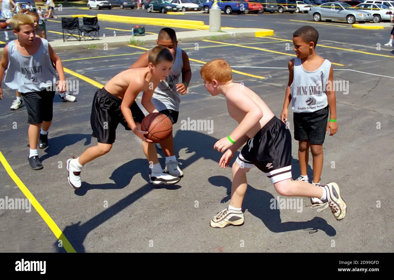 Young Boys male participants play 3 on 3 basketball outdoors Stock Photo