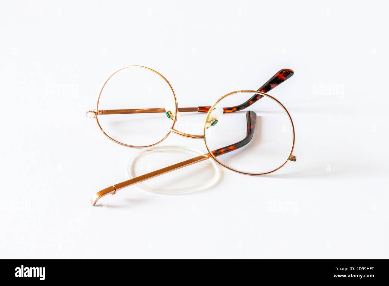 A broken pair of glasses on a white background Stock Photo
