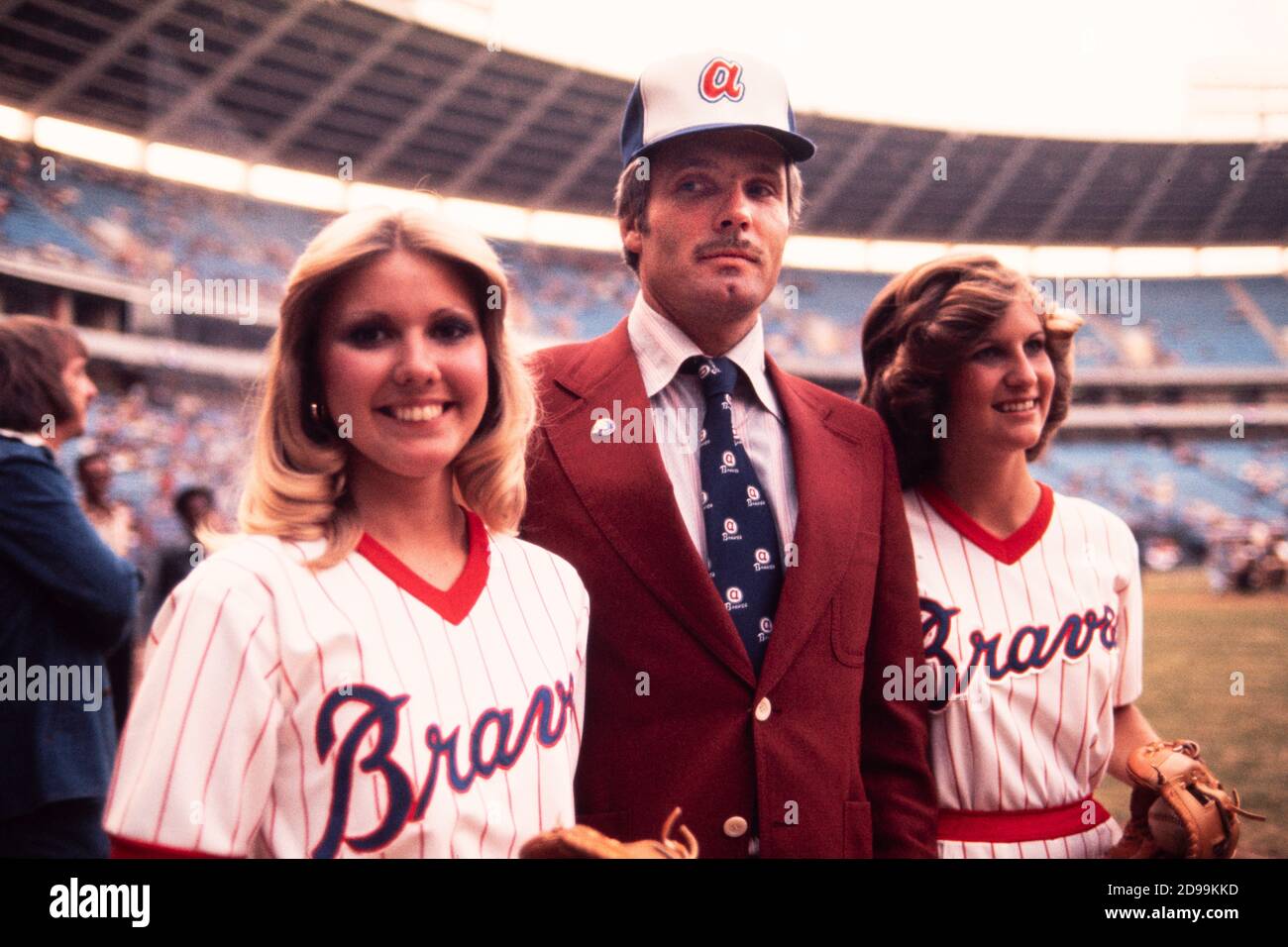 Ted Turner, millionaire broadcaster and owner of the Atlanta Braves baseball  team takes the field at Atlanta Fulton County Stadium in April 1976  escorted by pretty ballgirls and chomping on his trademark