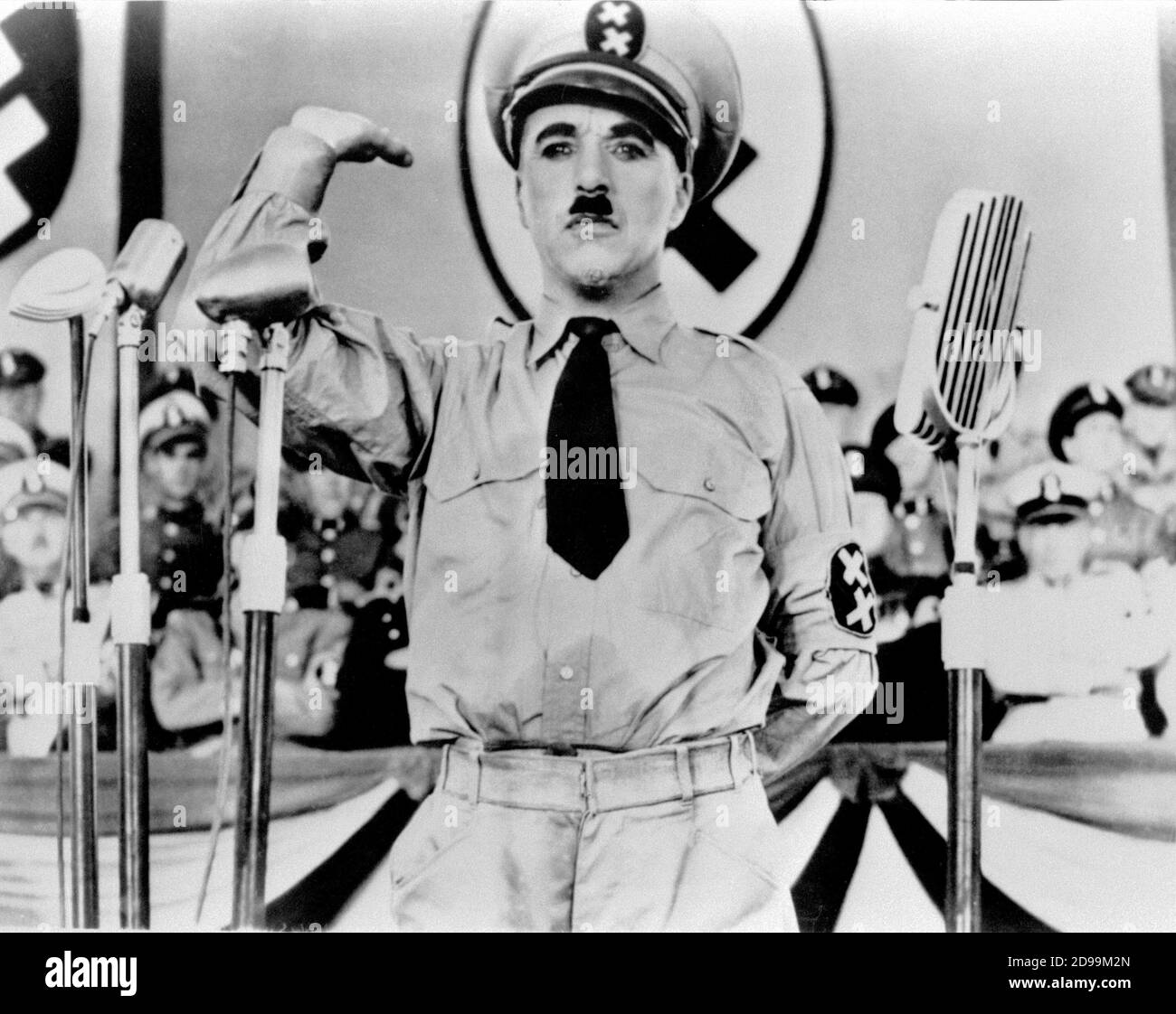 CHARLES  CHAPLIN  ( 1889 - 1977 ) as a HITLER look-a-like in THE GREAT DICTATOR ( 1940 - Il grande dittatore ) - military uniform - uniforme militare - cravatta - tie - WWII - Seconda guerra mondiale - baffi - moustache - nazi - nazist - nazism - nazista - nazismo - sosia - microfono - microphone  ----  Archivio GBB Stock Photo