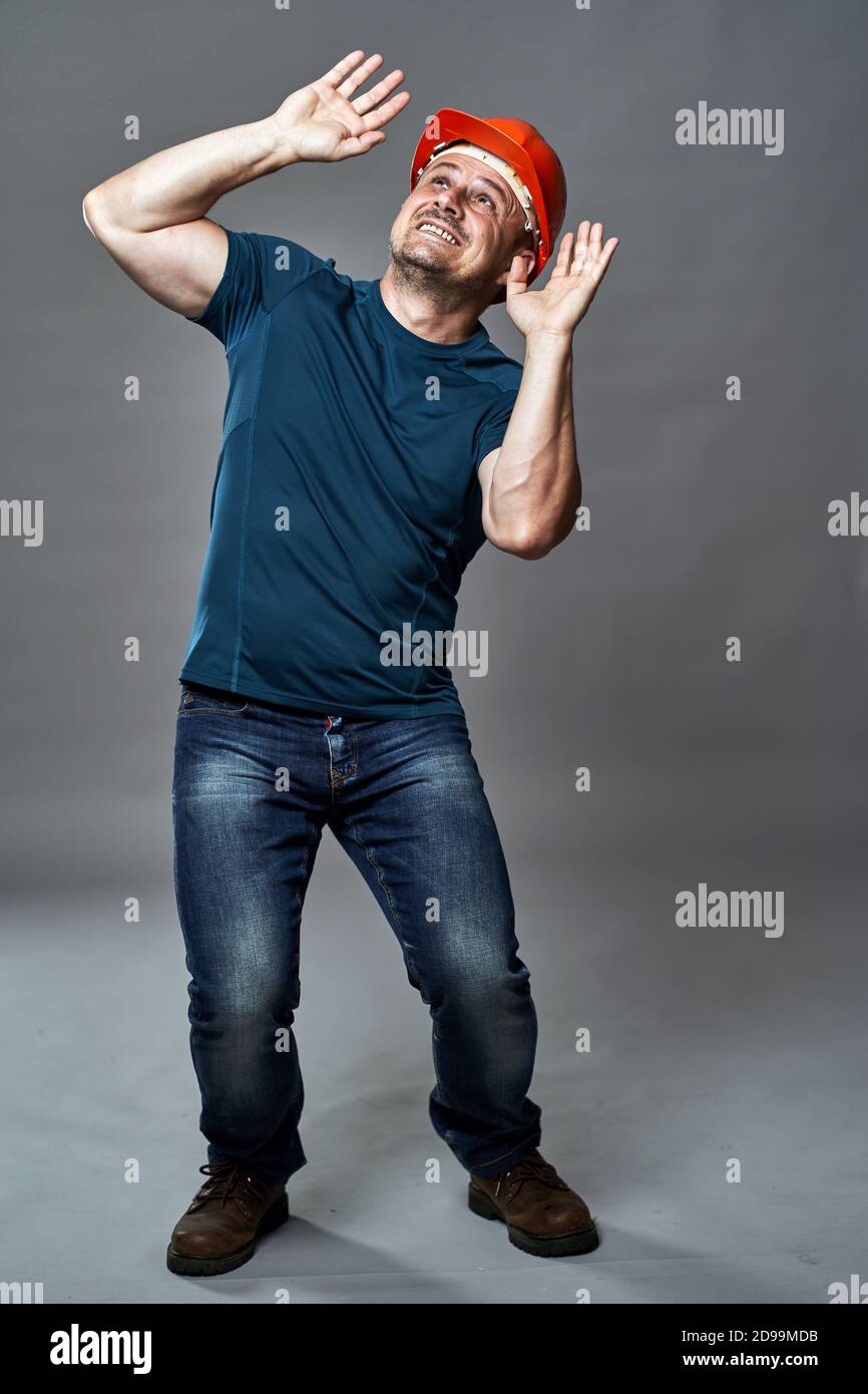 Engineer scared of something about to drop on his head Stock Photo - Alamy