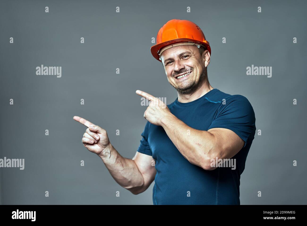 Engineer in hardhat pointing to the left side of the image Stock Photo