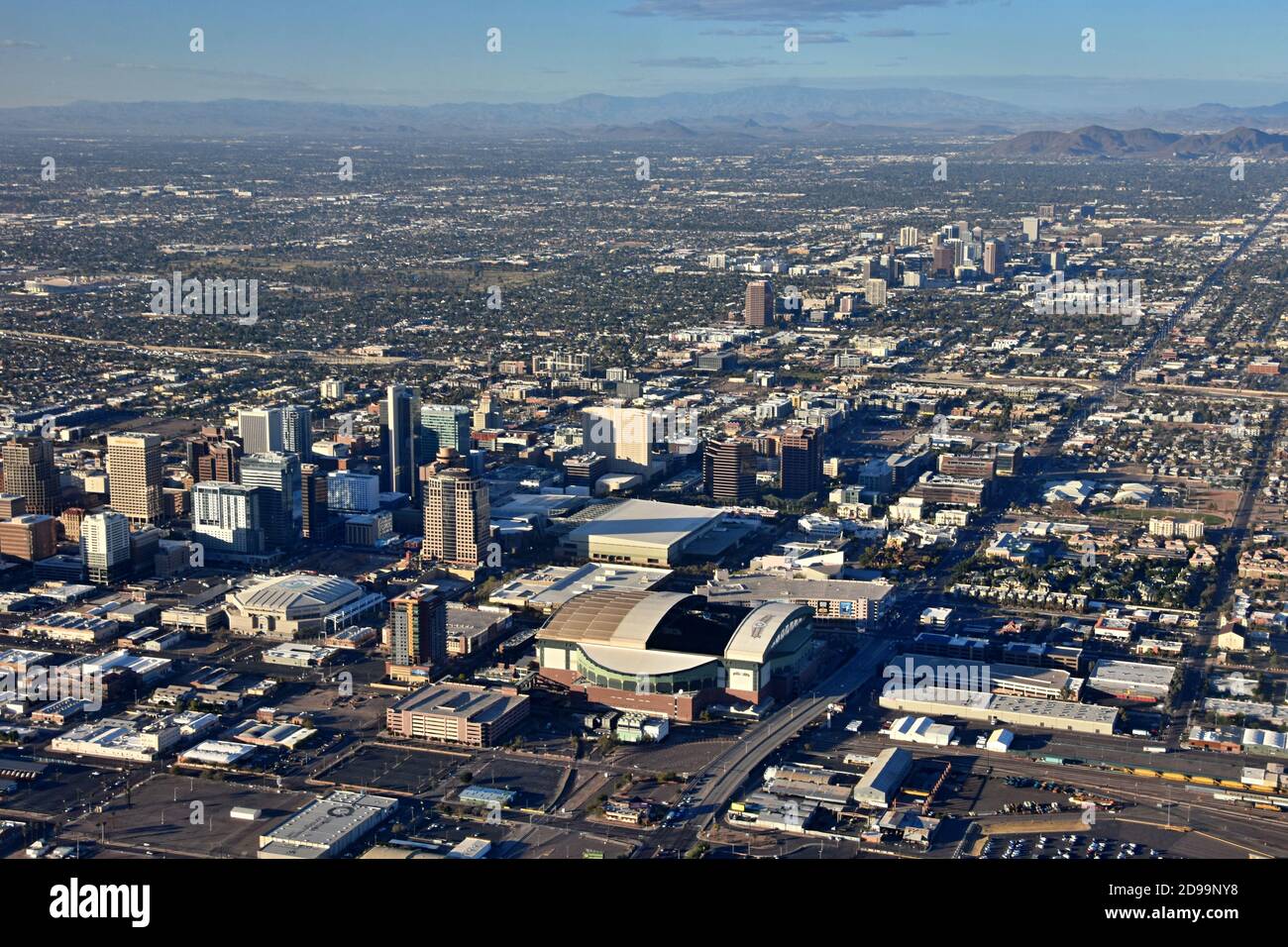 Aerial view from the airplane of downtown Phoenix, Arizona with sport stadiums and skyscrapers and city landscape, North mountain in the background Stock Photo