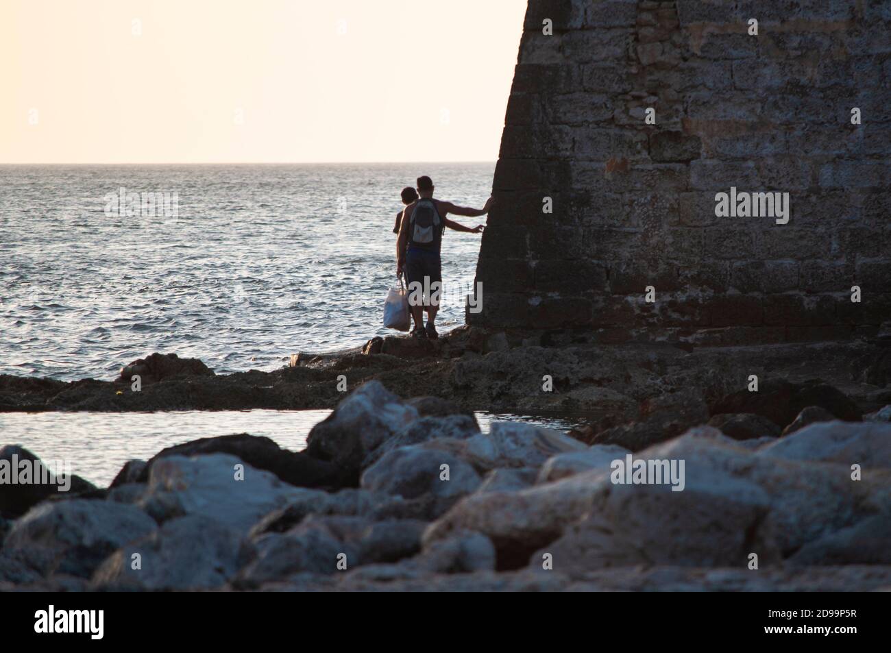People walking on a rocks in front of the sea Stock Photo - Alamy