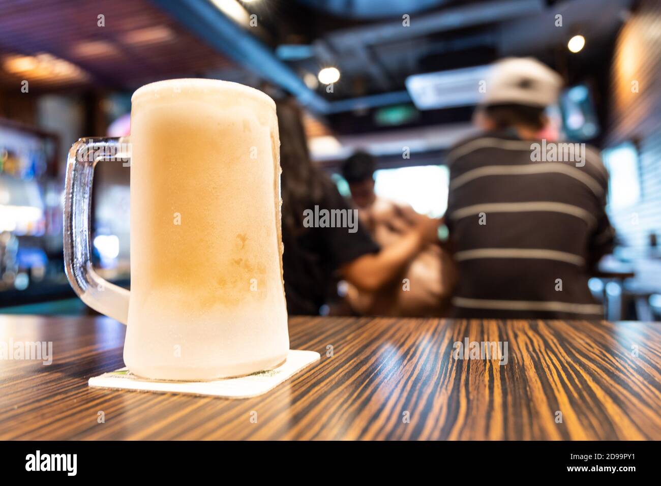 Pint of very cold refreshing fronsty beer with pub background Stock Photo