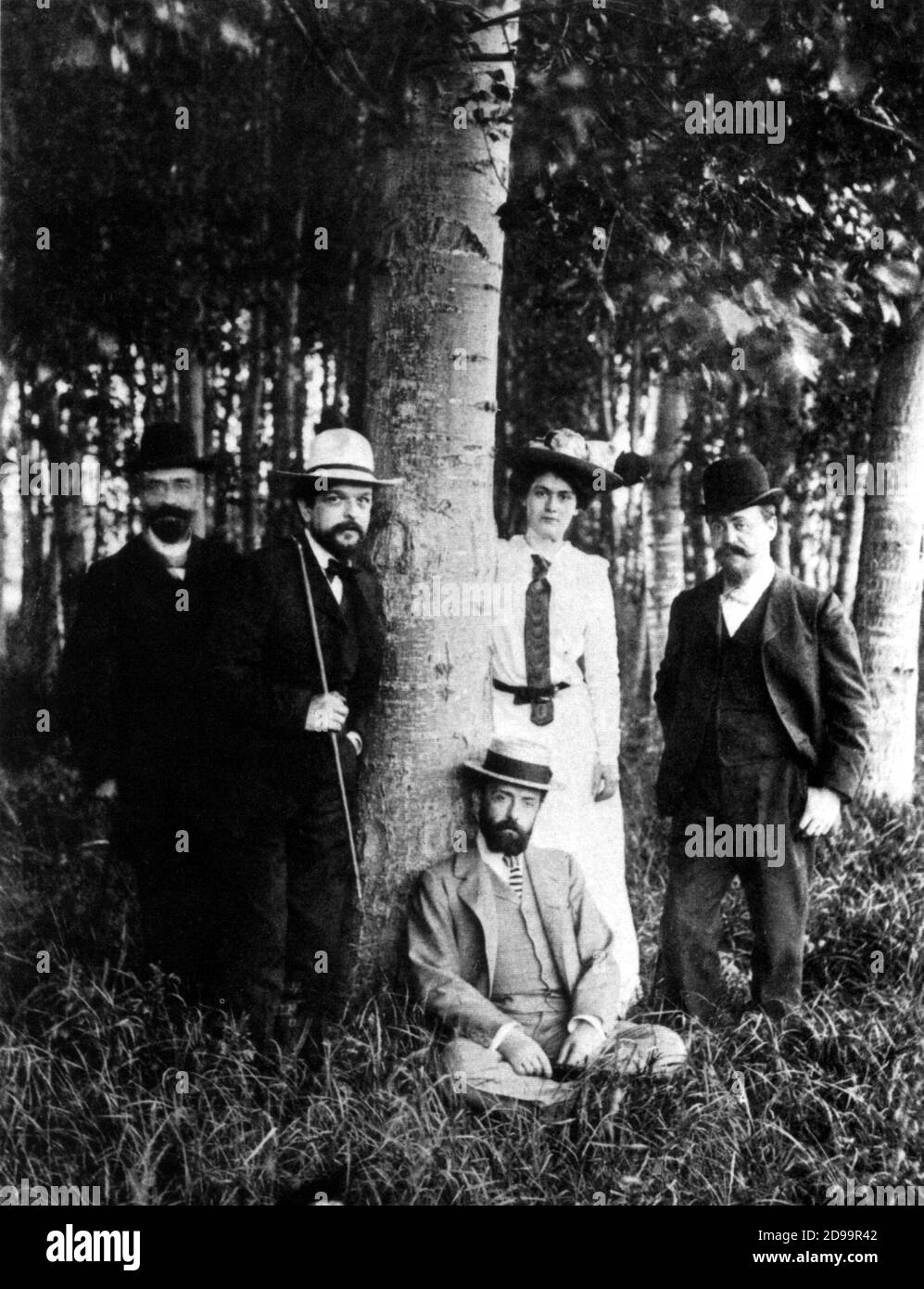 1902 , Eragny , FRANCE : The french music composer  CLAUDE Achille DEBUSSY ( 1862 - 1918 ) - ( in the photo the man with white hat and cane ) with the wife Lilly ( Rosalie Textier , mannequin for the Sisters Callot , married debussy in 1902 )  , the composer PAUL  DUKAS  ( Paris 1865 - 1935 ) and Pierre Laloy - MUSICISTA - COMPOSITORE - MUSICA CLASSICA - IMPRESSIONISMO - IMPRESSIONISM - impressionista - impressionist -  balletto - ballet - hat - cappello - cane - bastone - tie - cravatta - bosco - wood - albero - tree  ----  Archivio GBB Stock Photo