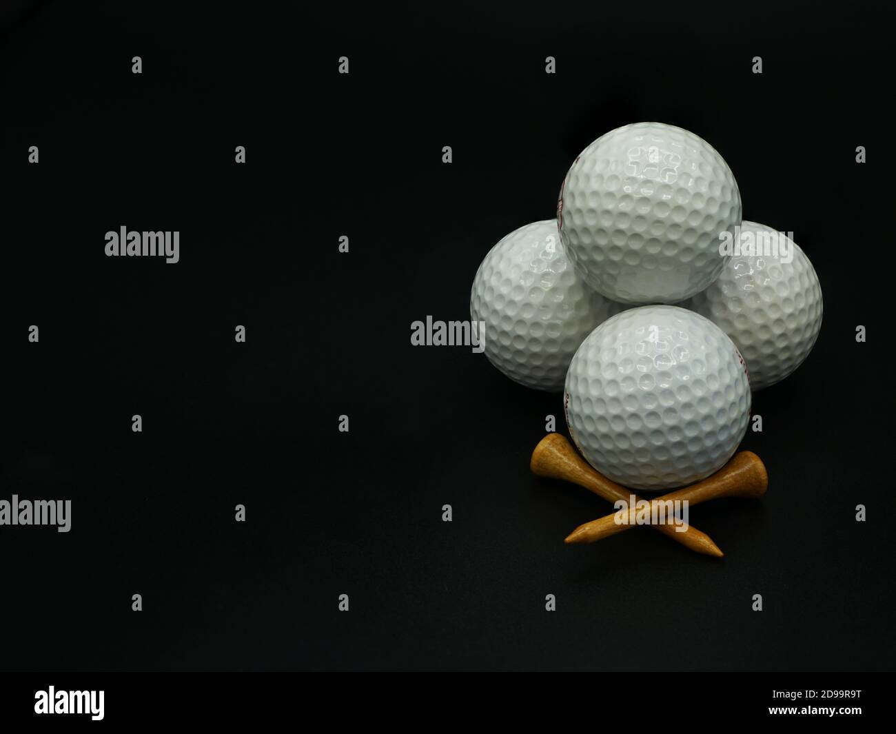 Stacked golf balls and tees on black background with copy space Stock ...