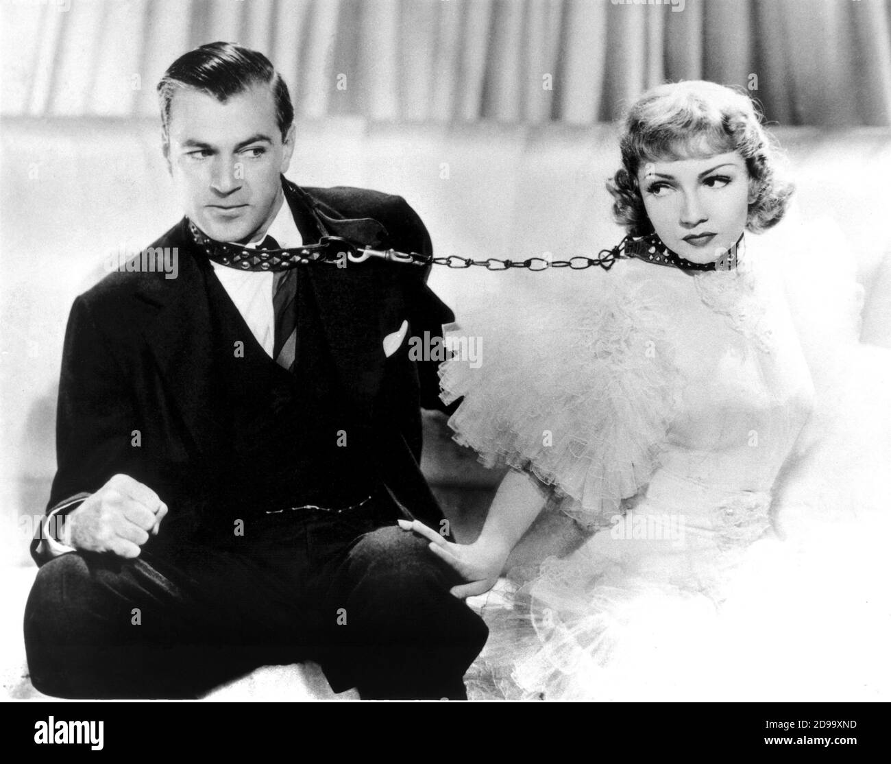 The movie actors GARY  COOPER and CLAUDETTE  COLBERT  in ' Bluebeard's Eight Wife ' ( 1938 - L' ottava moglie di Barbablù ) by Ernst Lubitsch - MOVIE - FILM - Hollywood -PARAMOUNT -  CINEMA - marito e moglie - matrimonio - guinzaglio - catena - tulle - capelli biondi - blonde hair - amanti - lovers - legame - husband - wife - marriage - love-match - matrimoniale - matrimonial - conjugal - letto matrimoniale - double room - bed - leash - lead - chain - chains - catene -  CULT - scena - scene ----  Archivio GBB Stock Photo