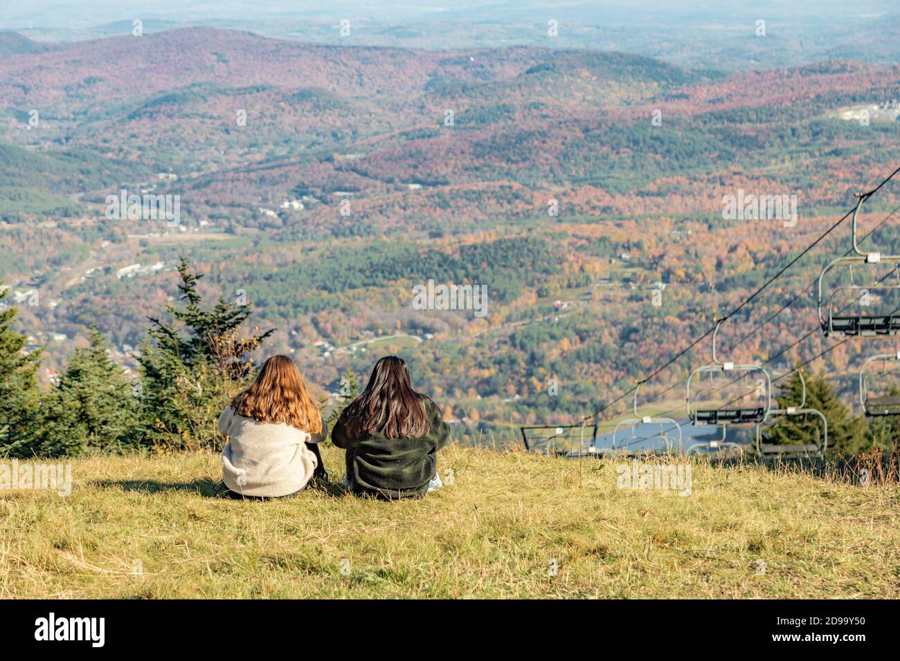 two young women sitting on top of Okemo looking at the view, Ludlow, VT Stock Photo
