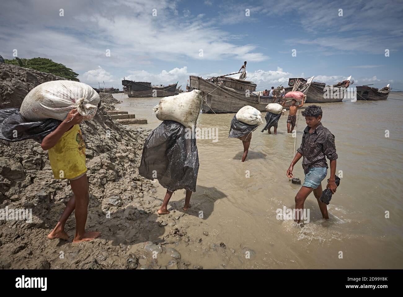 Kutubdia, Bangladesh, July 2009 - A group of people carry a boat by hand for the disappearance of the port due to rising sea levels due to climate cha Stock Photo
