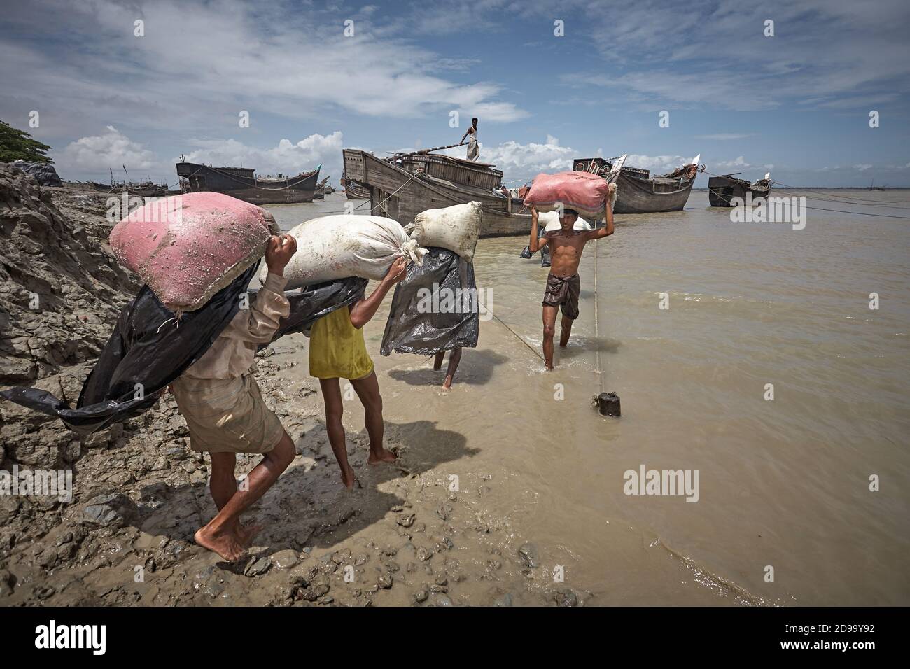 Kutubdia, Bangladesh, July 2009 - A group of people carry a boat by hand for the disappearance of the port due to rising sea levels due to climate cha Stock Photo