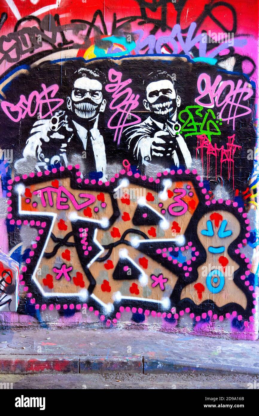 Graffiti of The Kray twins holding guns while wearing face masks at