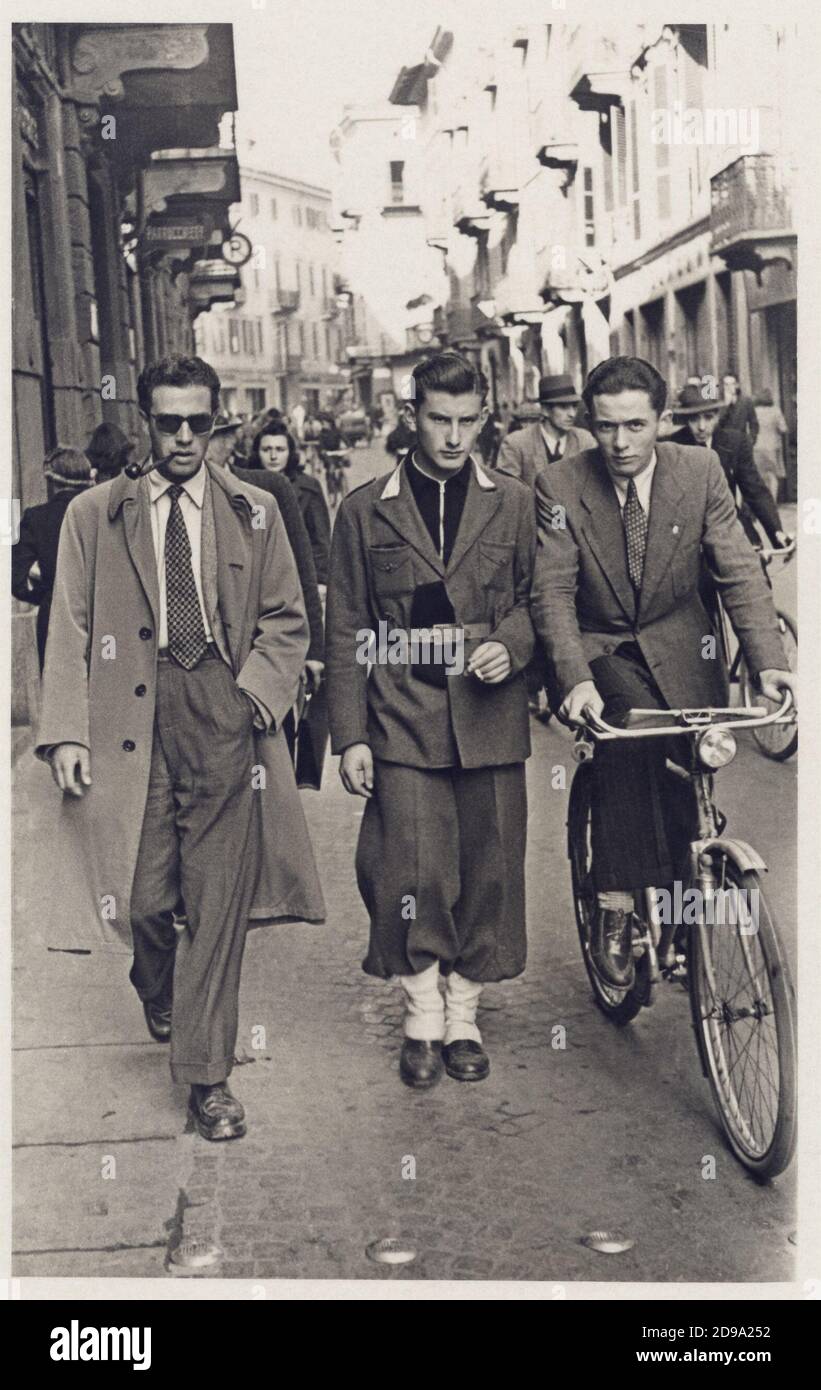 1940 ca , BIELLA , Piemonte , ITALY : Young italian walking in the street - WW 2 - II - WORLD WAR 2nd - SECONDA GUERRA MONDIALE - FASCISMO - FASCISTA - FASCISM - ANNI QUARANTA - 40's - '40 - bicicletta - bicycle - strada - folla - people  - portrait - ritratto -   giovanotto - giovanotti - young man - men  - uomo - uomini - FOTO STORICHE - HISTORY PHOTOS - STOCK  - ITALY - ITALIA - XX CENTURY - NOVECENTO  -  cravatta - tie - pipa - pipe - sunglasses - occhiali da sole - AMICO - AMICI - FRIENDS  © Archivio GBB / Stock Photo