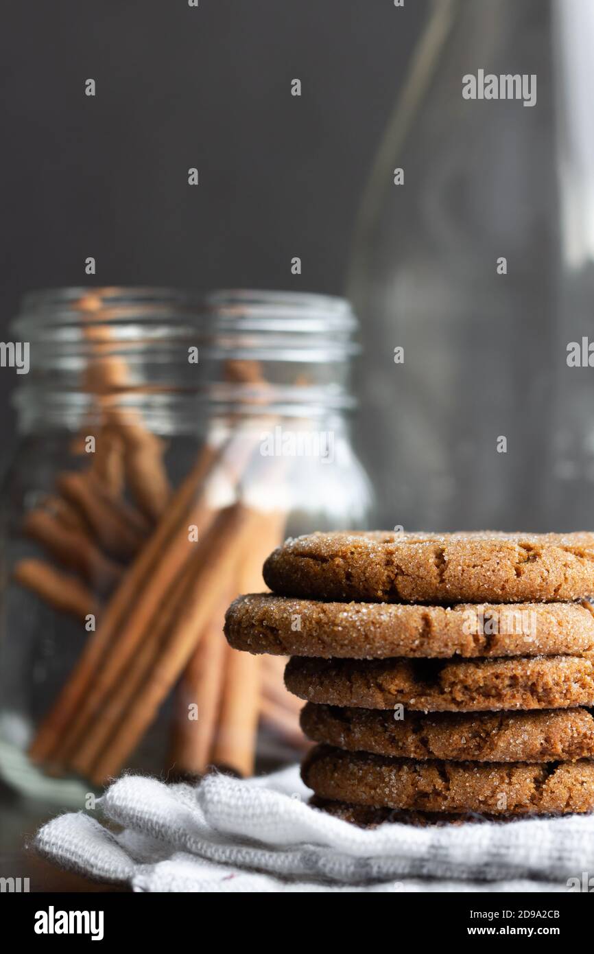 Ginger snap cookies with cinnamon sticks and glass bottle, holiday food, Christmas cookies Stock Photo