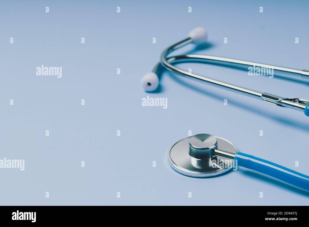 Close-up of Blue stethoscope of doctor for checkup on blue background Stock Photo