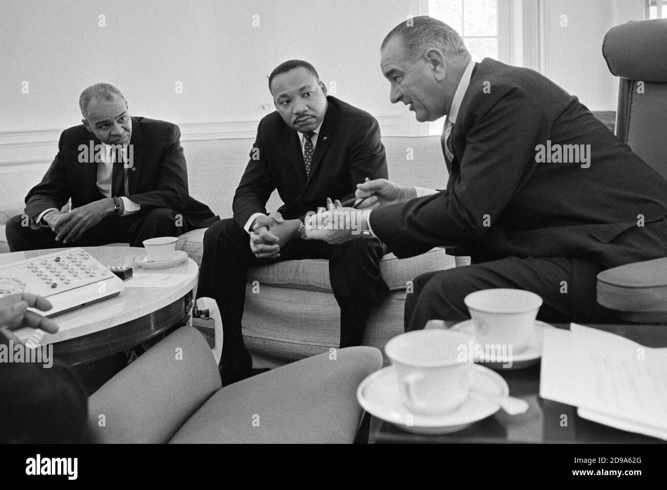 Roy Wilkins and Dr. Martin Luther King, Jr. meet with President Lyndon B. Johnson in the Oval Office of the White House on January 18, 1964. Stock Photo