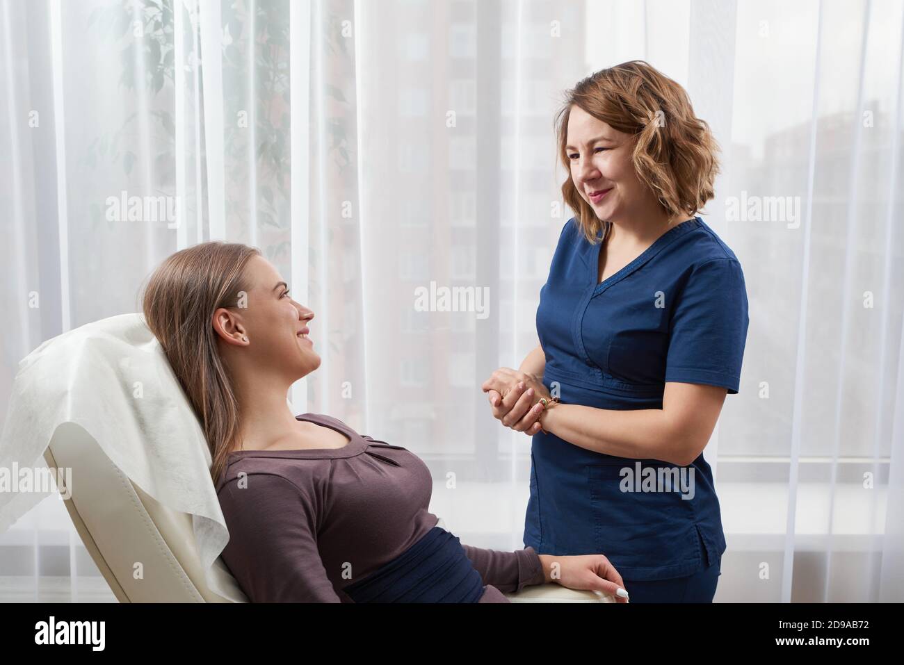 doctor is talking with young female patient in her office Stock Photo ...