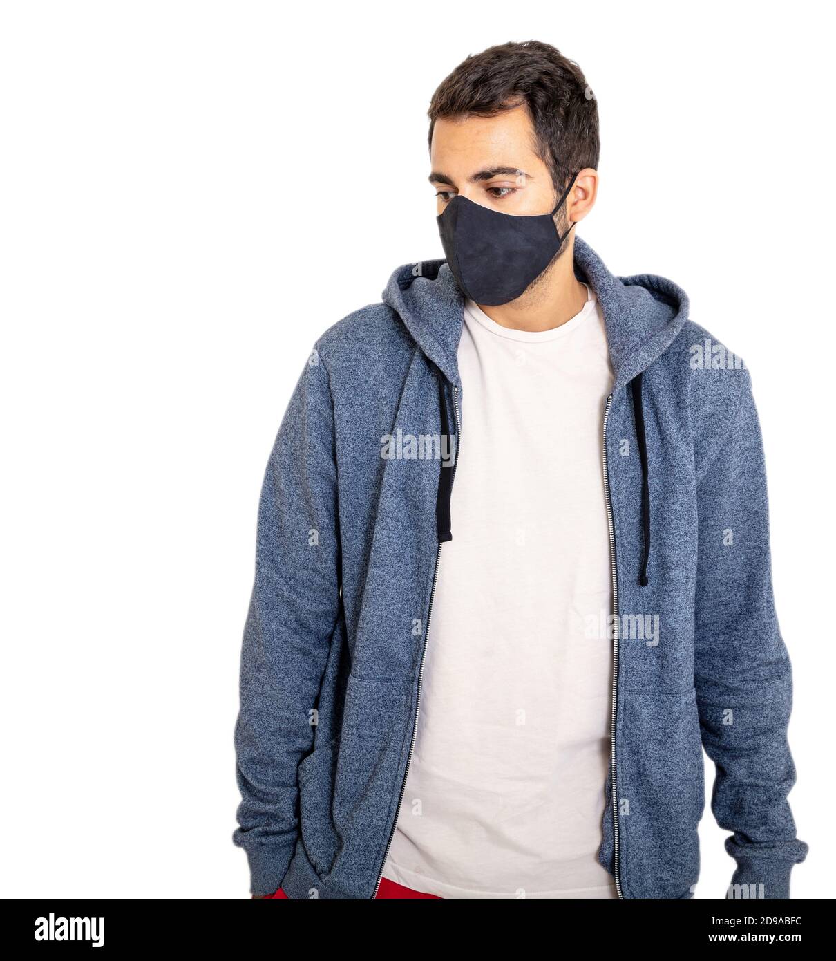 Coronavirus days, man with COVID 19 protective face mask, wearing a blank tshirt and gray color hoodie isolated against white background, closeup view Stock Photo