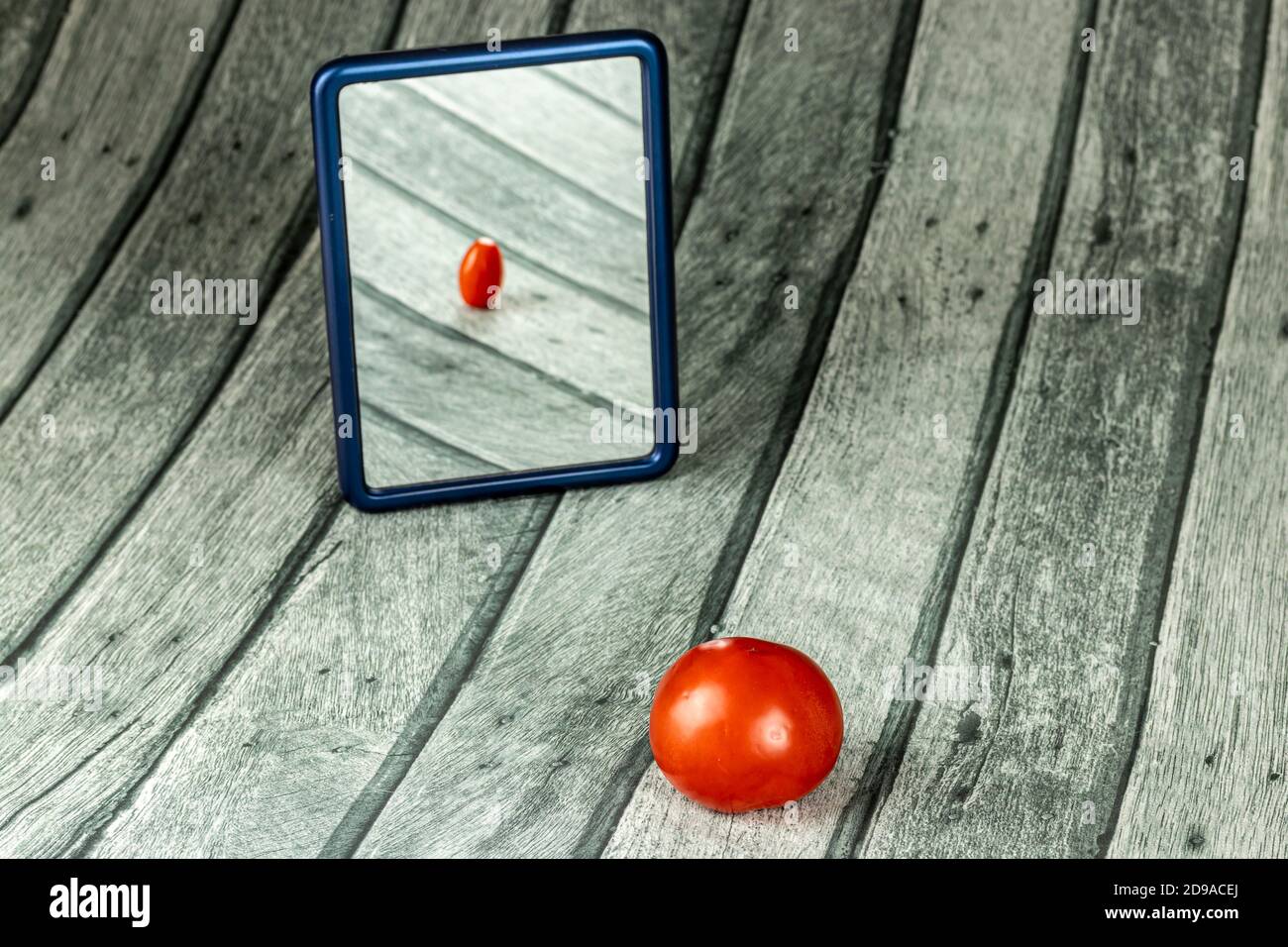 Mirror with a tomato Stock Photo