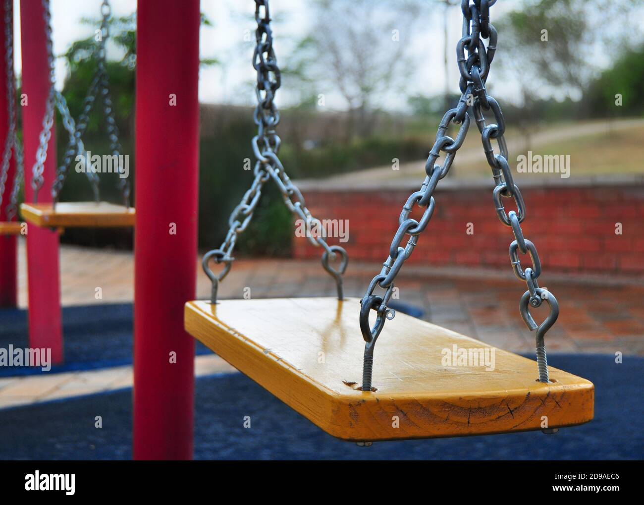 Empty wooden swings on a playground, playground without children Stock