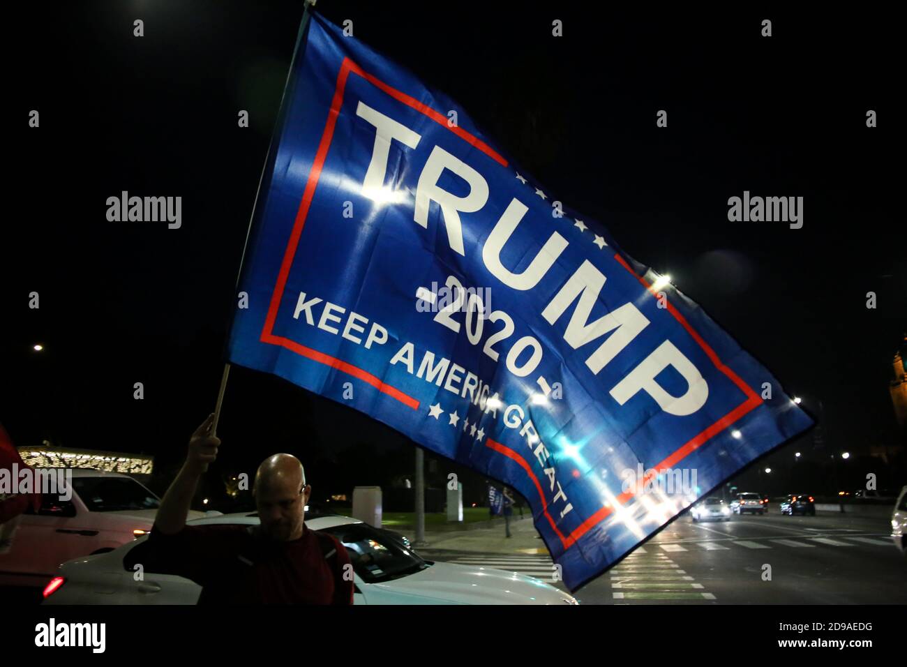 A Supporter Of President Trump Waves A Trump Flag That Reads Trump Keep America Great
