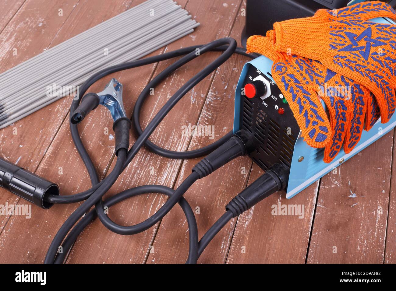 Industrial tool - Welding machine, electrode and working gloves on a wooden background Stock Photo
