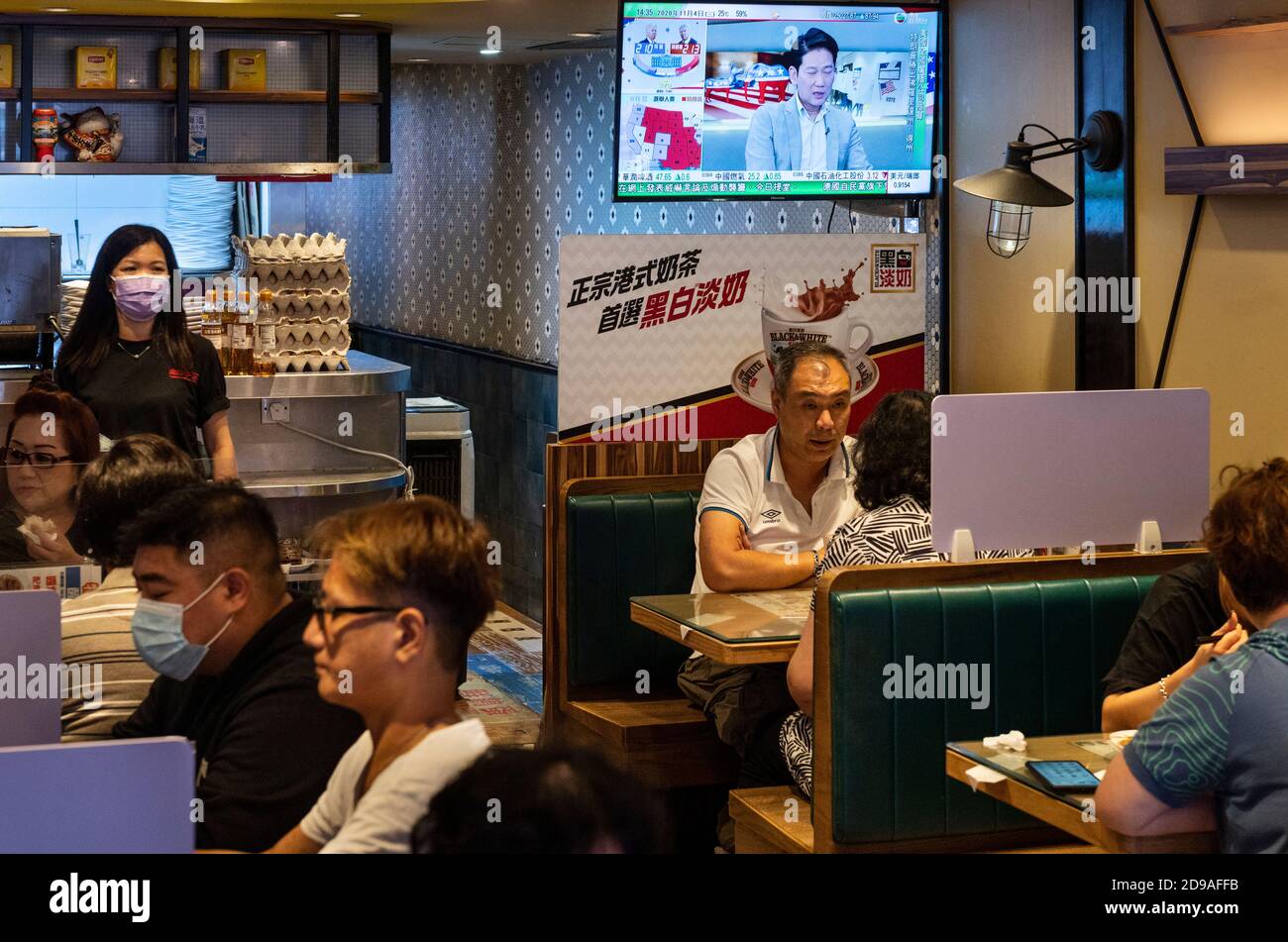 At a local restaurant, people eat and watch TV during news report about the US presidential. Stock Photo