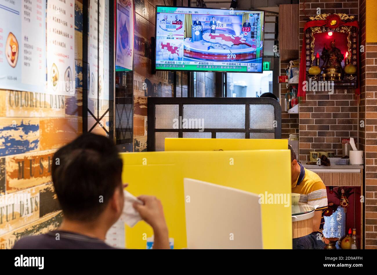At a local restaurant, people eat and watch TV during news report about the US presidential election. Stock Photo