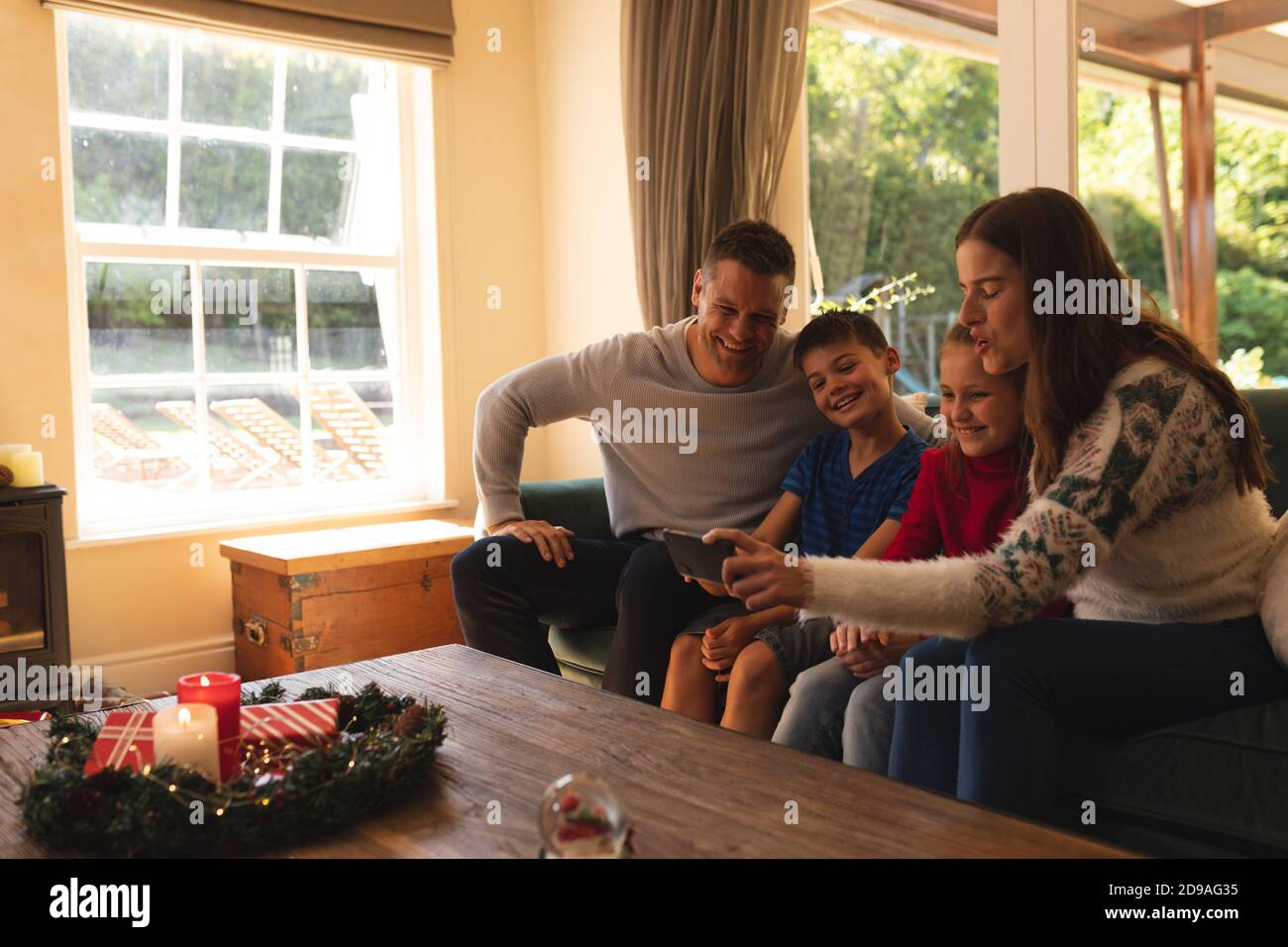 Caucasian family relaxing in living room at christmas time Stock Photo