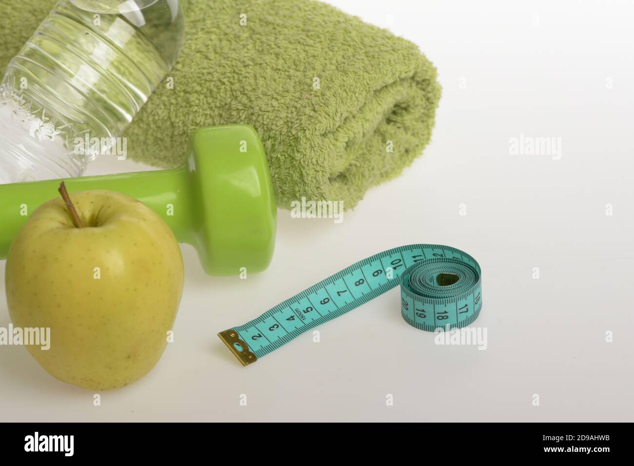 Healthy Lifestyle And Low Calorie Food Concept Dumbbell In Green Color Water Bottle Measure Tape Towel