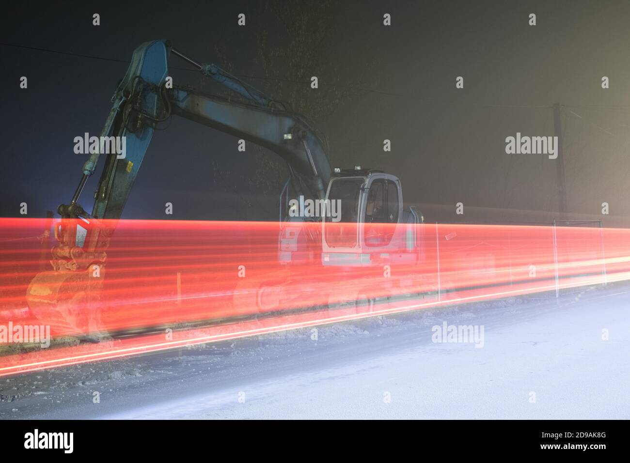 Blue excavator digger working at night on the street Stock Photo