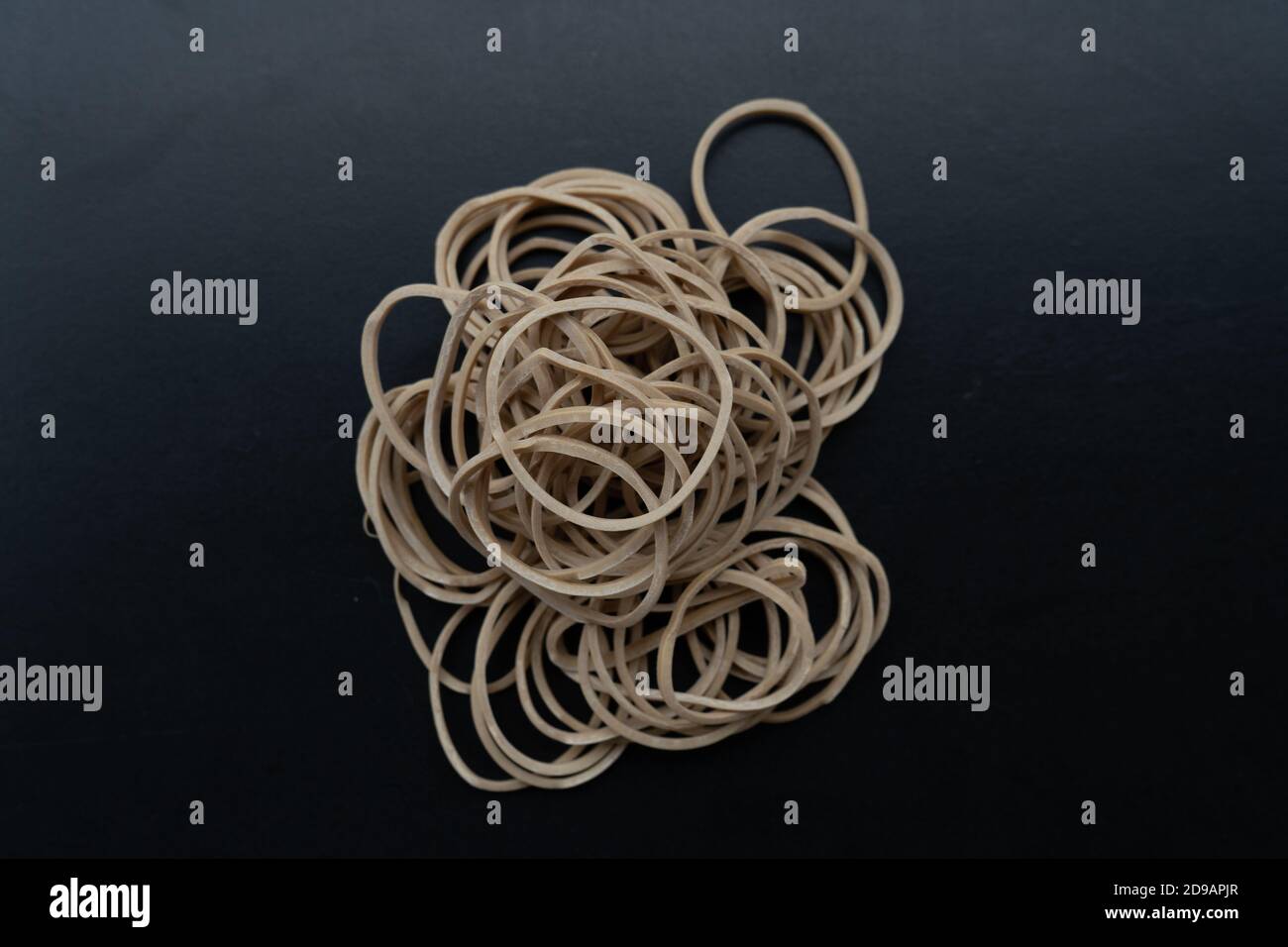 Top view of white elastic rubber bands isolated on a black background