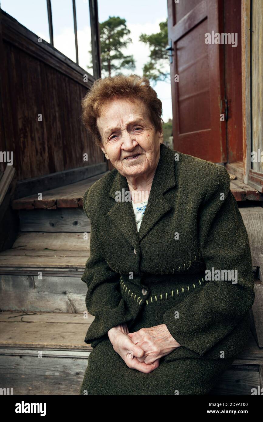 Old woman sitting on the porch of a rural house Stock Photo - Alamy