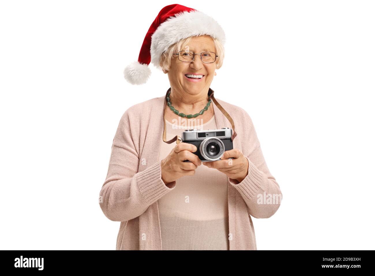 Elderly lady wearing a santa claus hat and holding a vintage camera ...