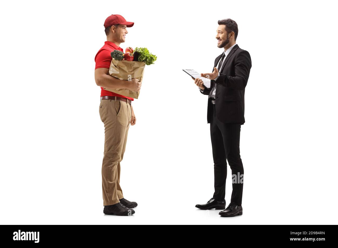 Full length profile shot of a manager talking to a food delivery courier isolated on white background Stock Photo