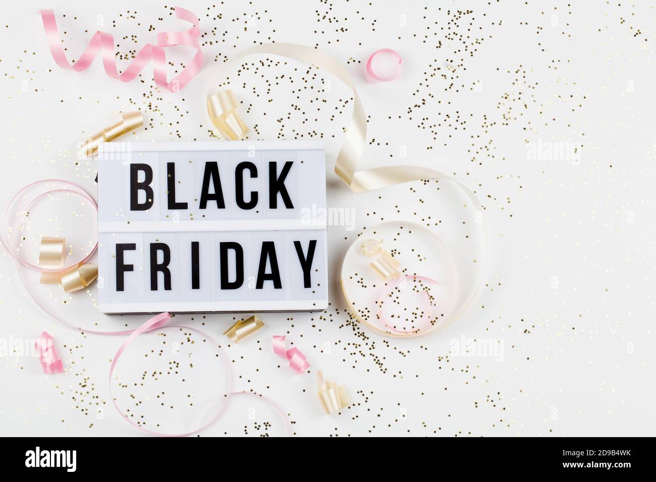 Black friday sale text on white lightbox, golden stars and holiday