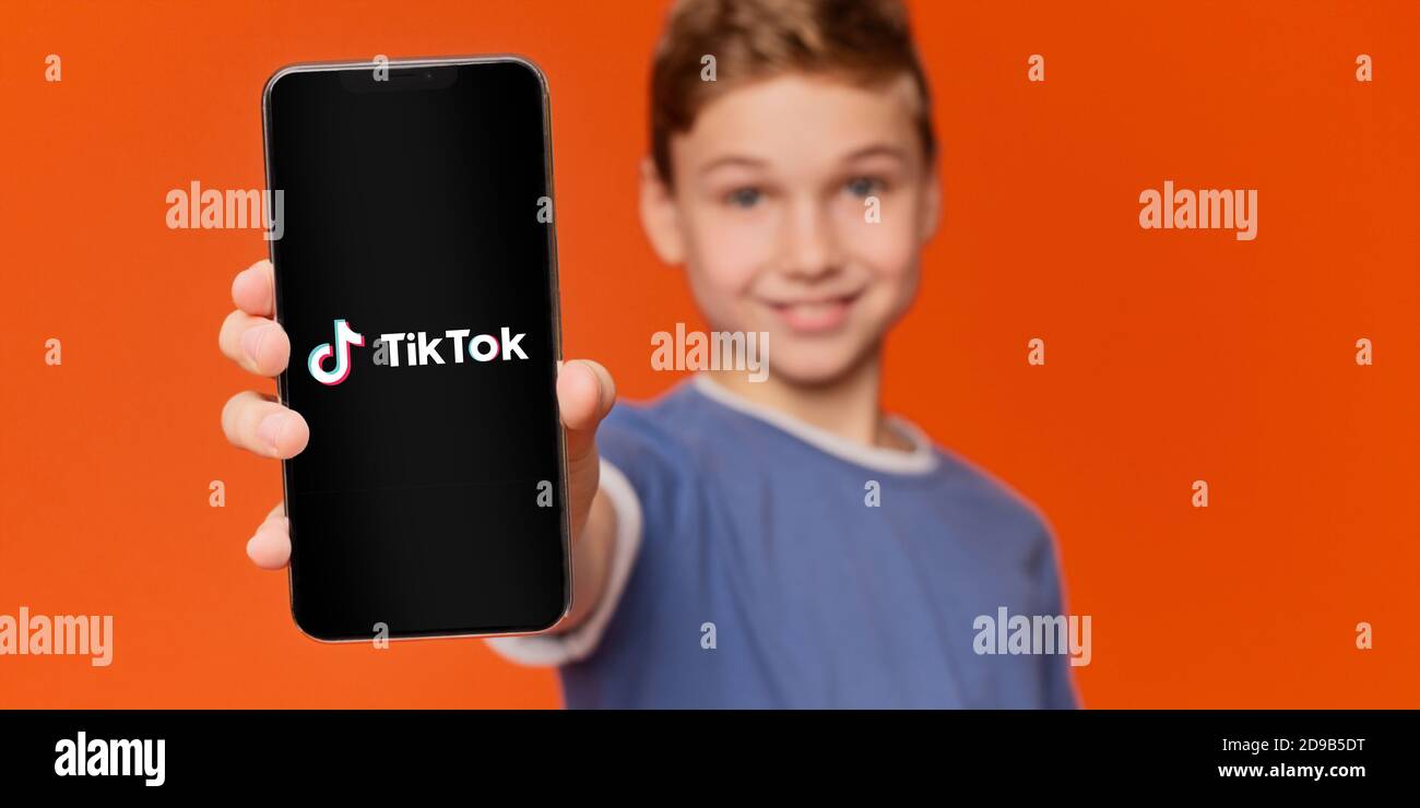 Boy holding smart phone with Tik Tok app Stock Photo