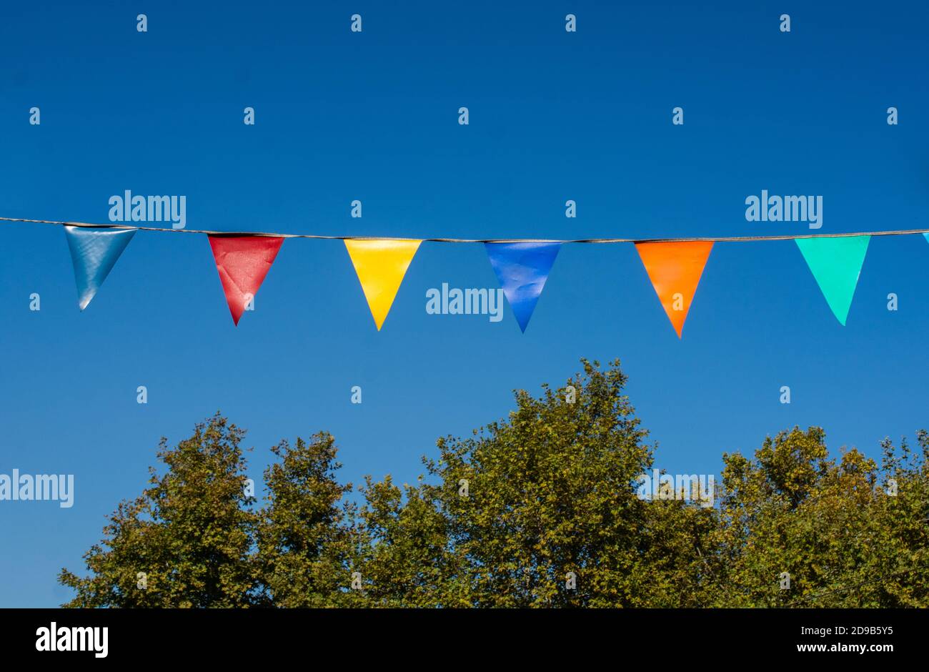 Colorful triangle bunting flags of various colors as festival concep ...