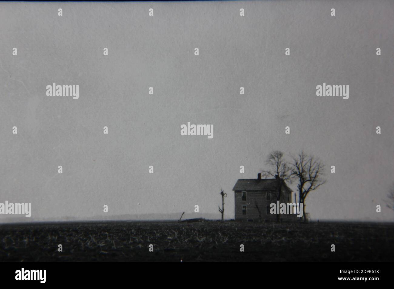 Fine 1970s vintage black and white photography of a lonely home sitting on a huge farm. Stock Photo