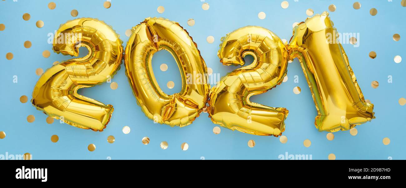2021 golden balloon text on blue background with confetti . Happy New year eve invitation with Christmas gold foil balloons 2021. Flat lay long web Stock Photo