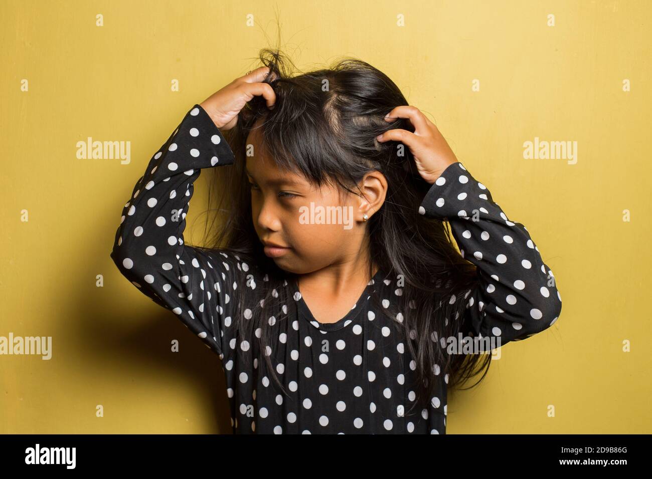 Asian little girl itching scratching her head Stock Photo Alamy