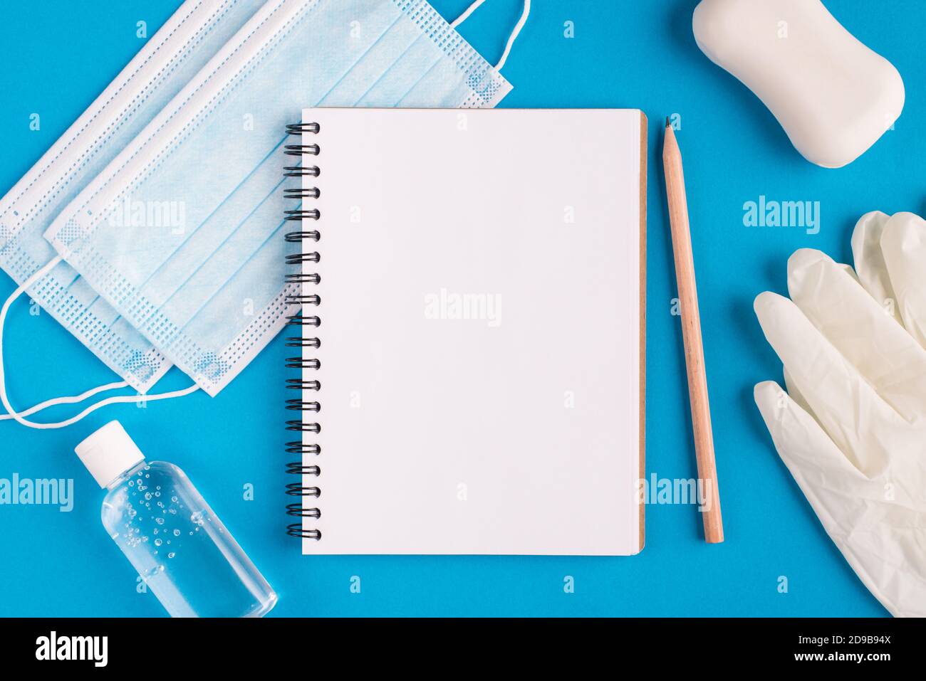 Working education study from home concept. Top layout flatlay close up photo of empty blank clear paper page open sketch pad disinfection bottle rubbe Stock Photo