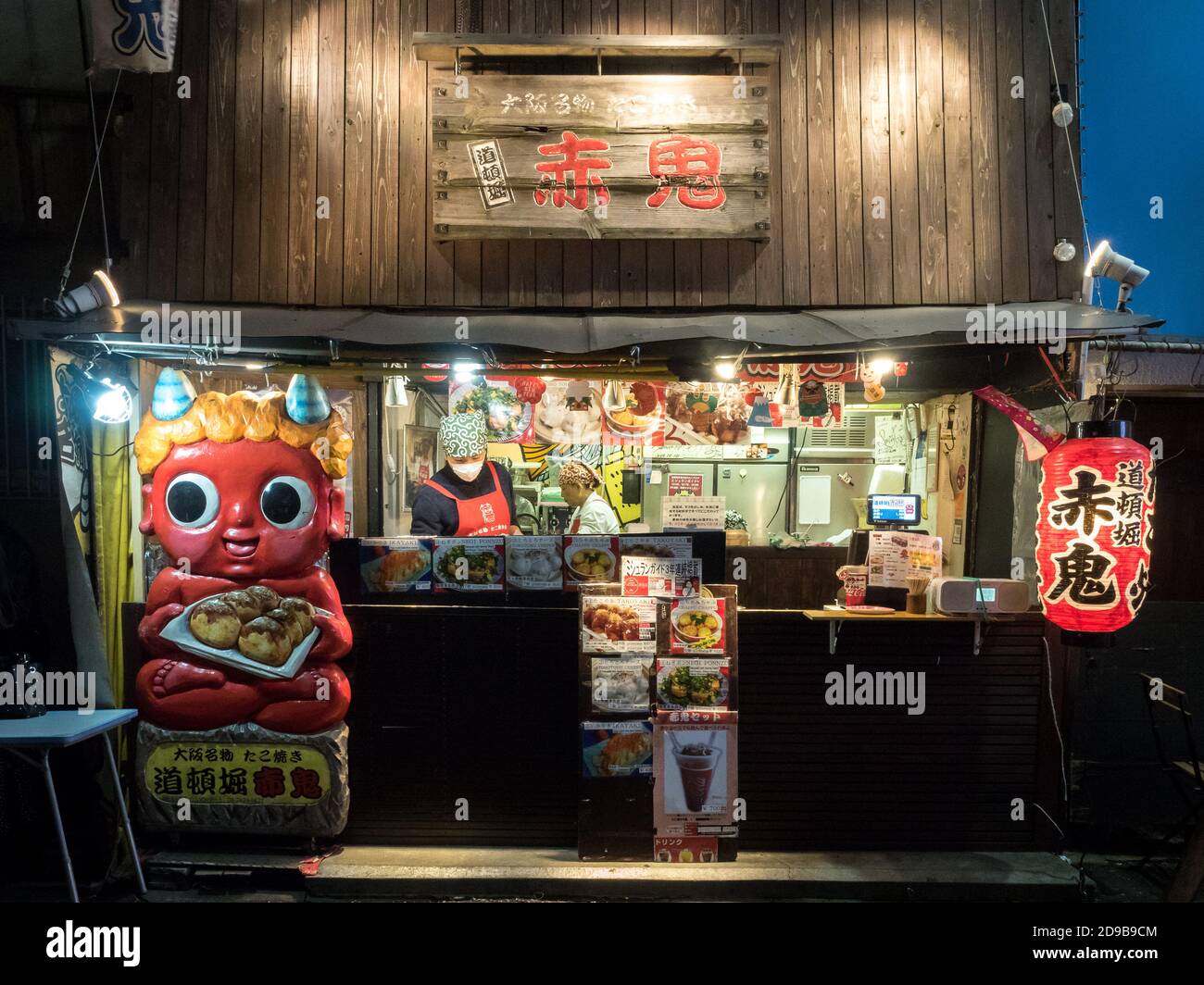 Osaka, Kansai, Japan - Small food restaurant in Dotonbori selling takoyaki, a Japanese snack filled with octopus and cooked in a special molded pan. Stock Photo