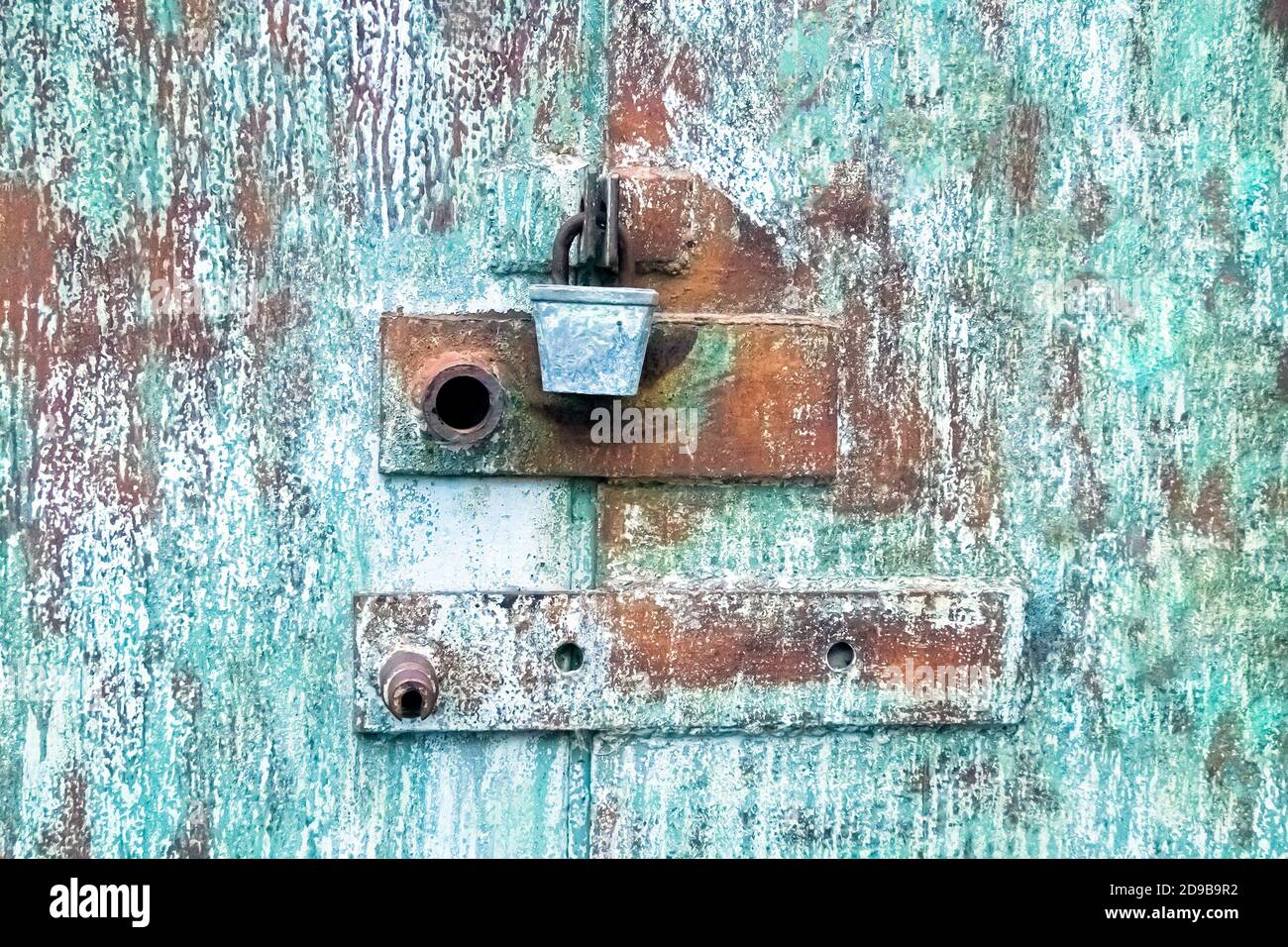 Metal texture with old lock in brown and blue. Silver padlock on old blue door. Stock Photo