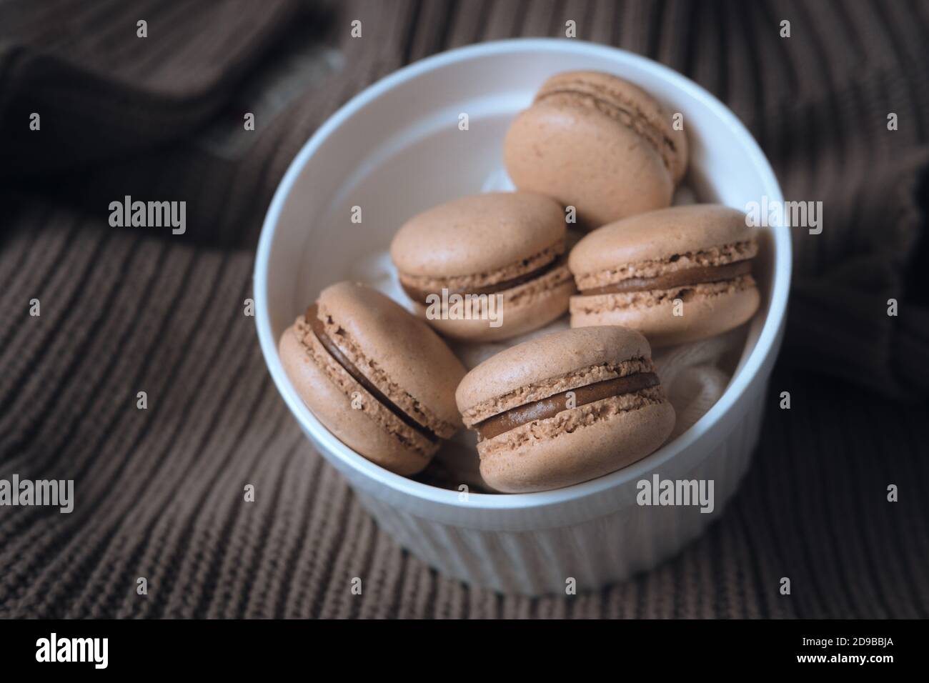 macaroons in a bowl.  caramel macaroons on a sweater. cozy autumn photography. photograph of food in brown tones. Stock Photo