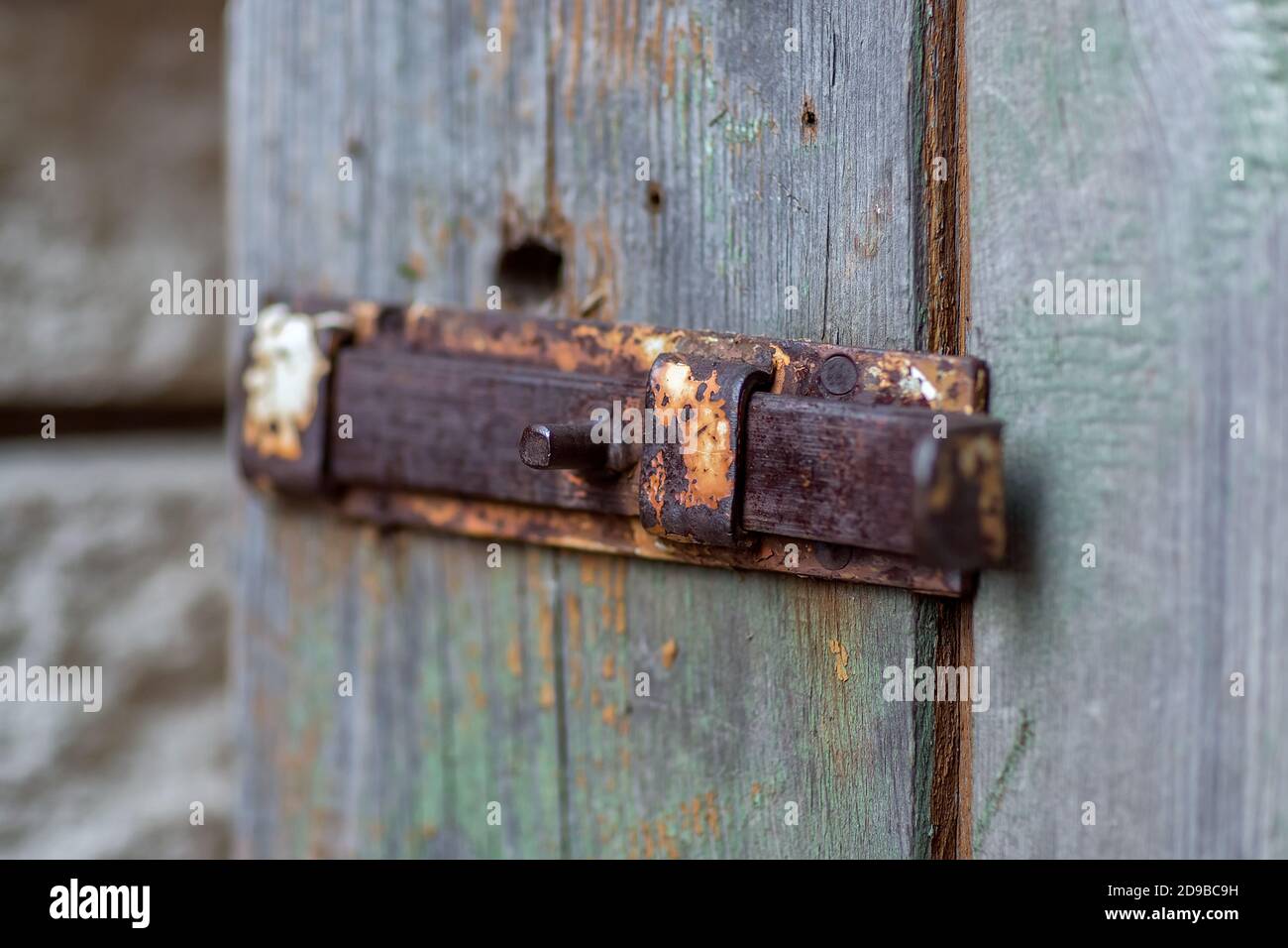 Texture of an old wooden door with an iron handle, bolt and latch Stock Photo
