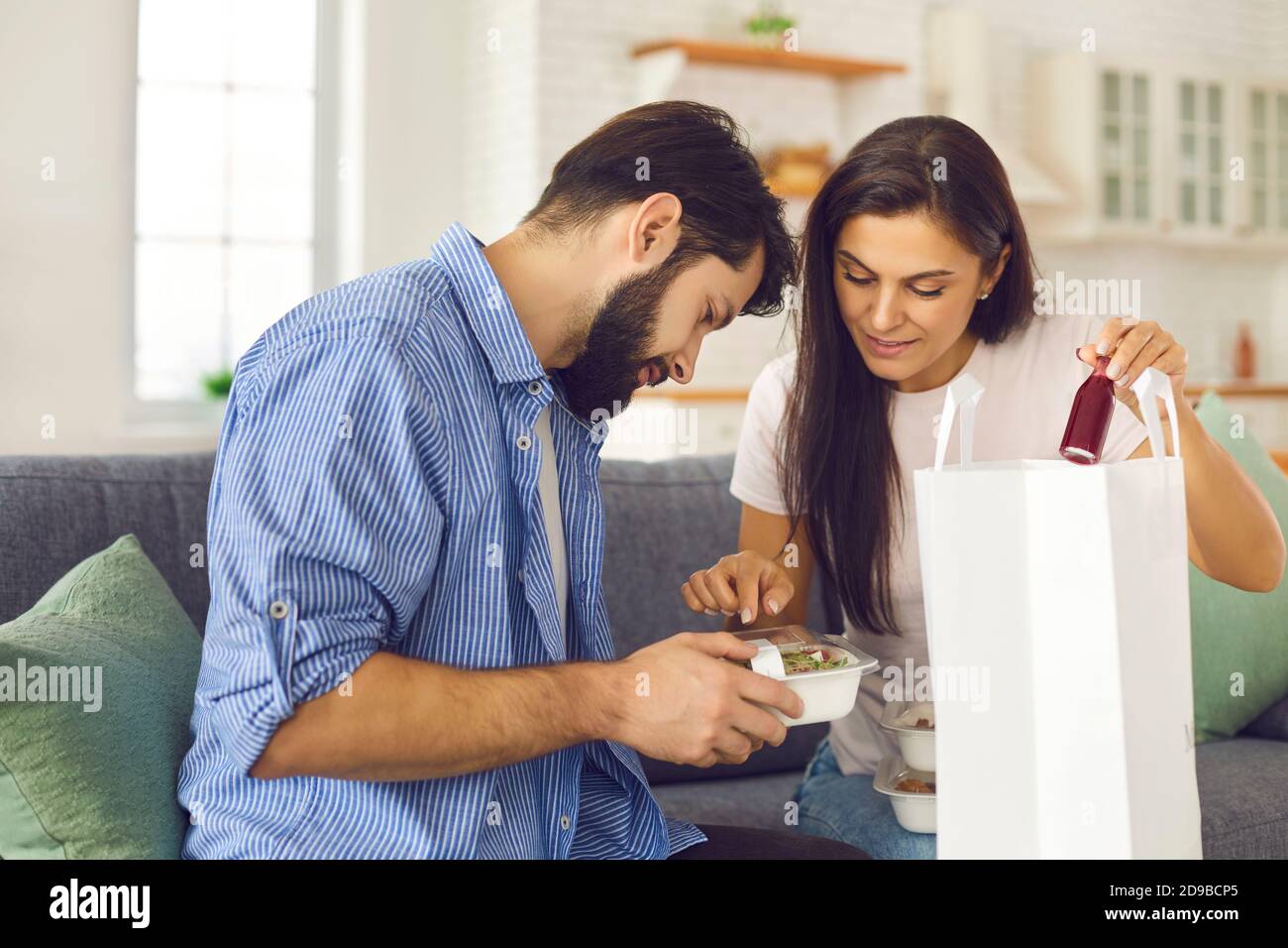 Couple take out the food containers and drinks they ordered from the