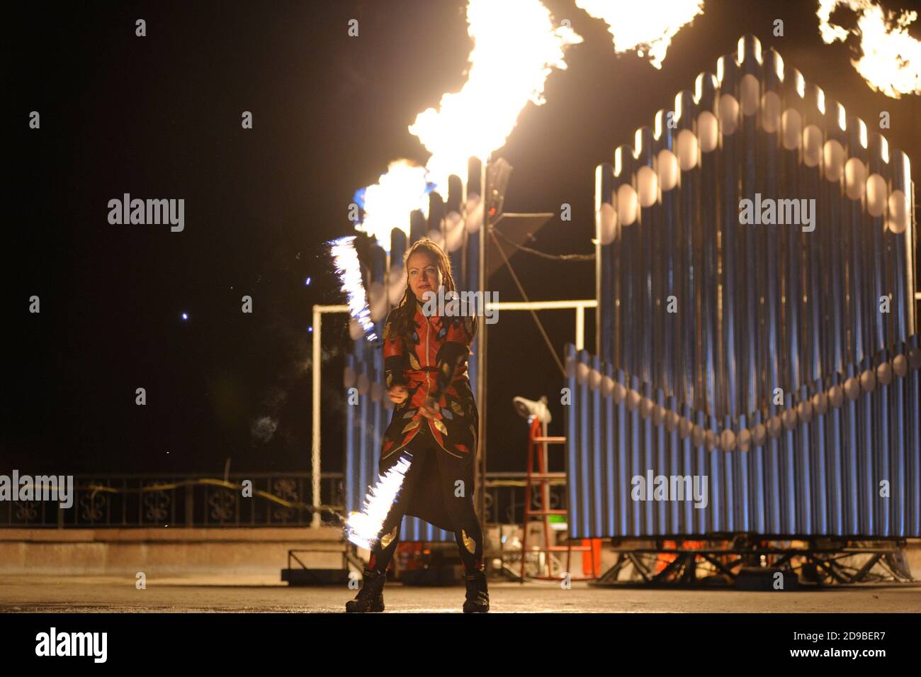 Fire juggler performing at night on stage, juggling with torches