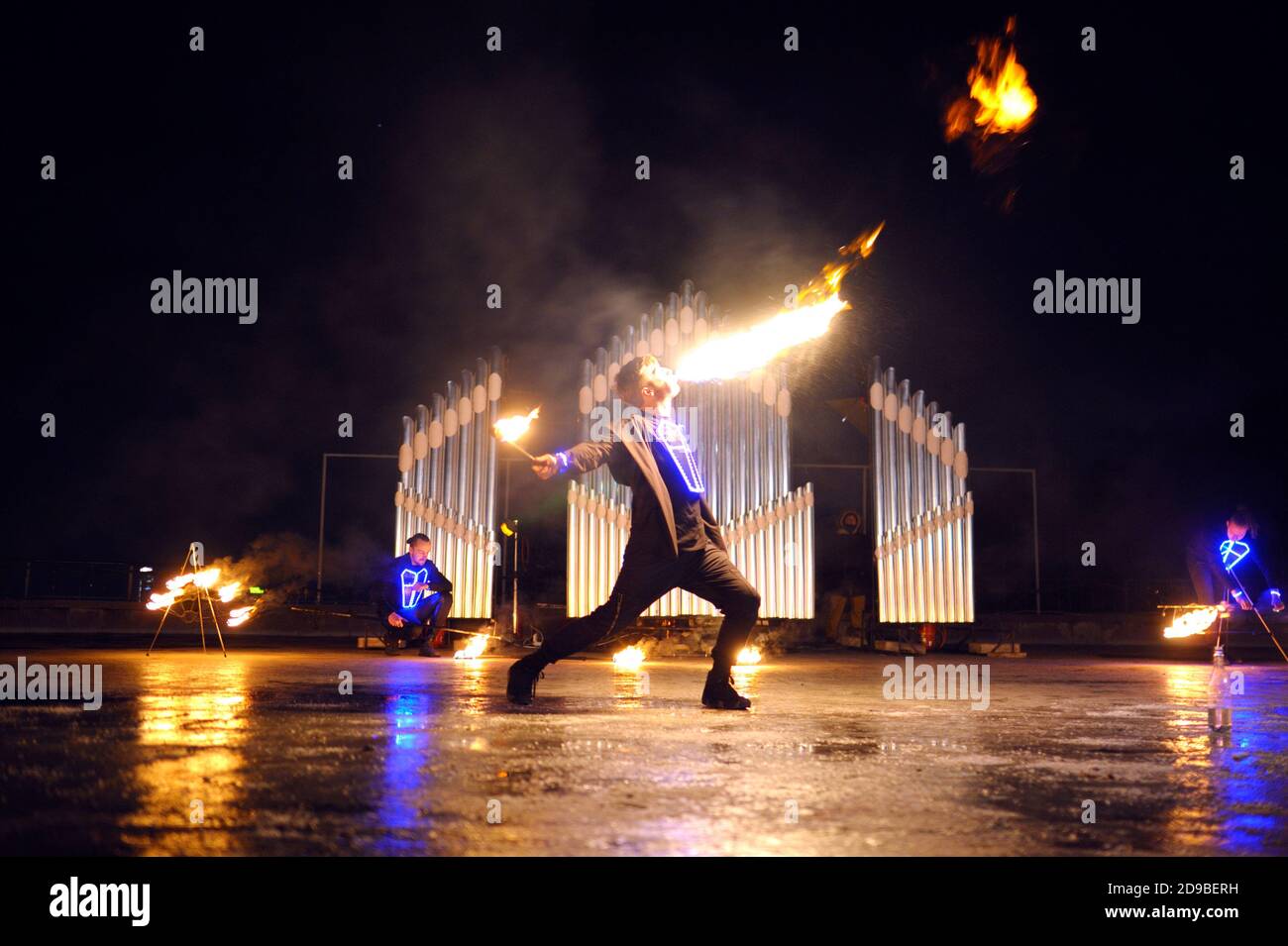 Fire juggler performing at night on stage, juggling with torches